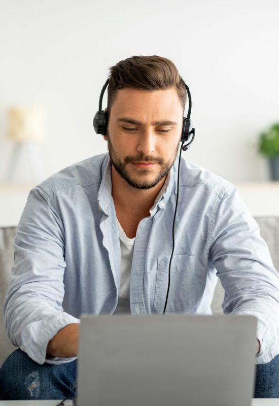 hotline support service millennial male call center operator in headset working with laptop at home hotline support service millennial male call center operator in headset working with laptop at home